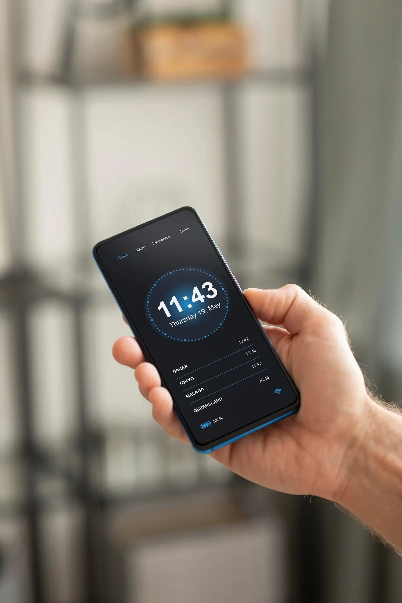 Un homme tient un smartphone avec une application de domotique.